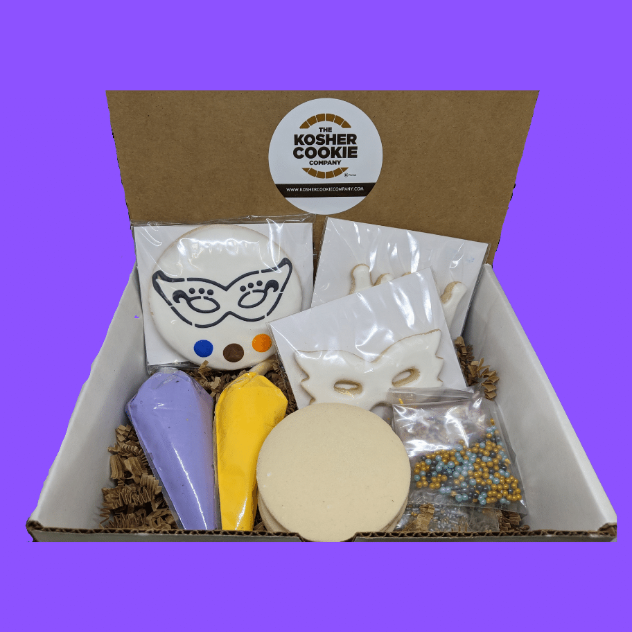 A box of assorted cookies with a Purim cookie decorating kit, including pre-frosted cookies, blank canvas cookies, frosting tubes, and sprinkles, arranged on a purple background.